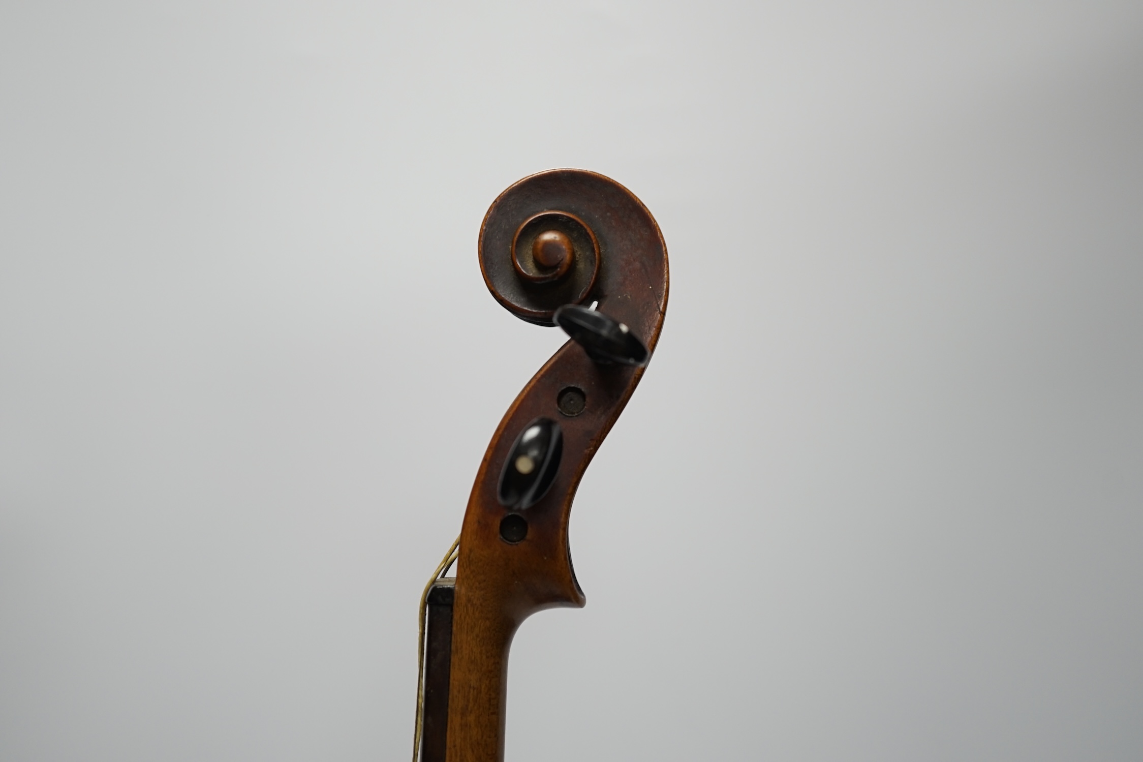 A late 19th century three quarter length violin with label; 'Medio-Fino', back measures 33cm